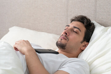 Handsome man suddenly slept during chatting or watching video on his smartphone
