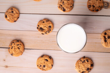 Glass of milk and brown cookies with chocolate. Oat, healthy cookies and milk cup, breakfast concept on kitchen. Copy space, flatlay.