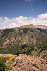 View of the hills and forest from the top of the mountain, in a sunny day.