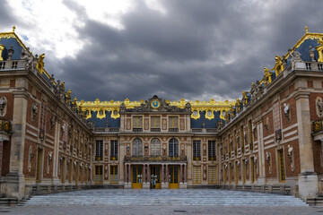 The main entrance to the Palace of Versailles just outside Paris, France is seen under a gloomy, overcast sky.