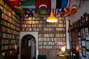 Many country flags in library interior with books.