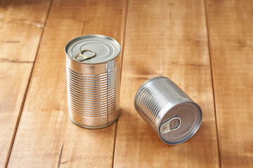 Iron tin can with tab opener on the wooden table.