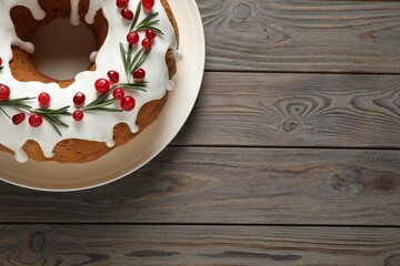 Traditional Christmas cake decorated with glaze, pomegranate seeds, cranberries and rosemary on...
