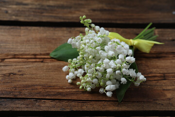 Beautiful lily of the valley flowers on wooden table