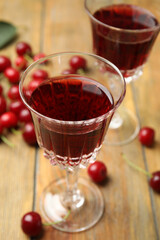 Delicious cherry wine with ripe juicy berries on wooden table