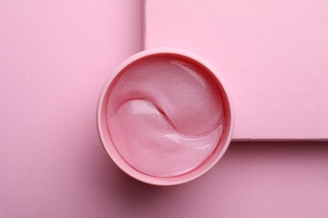 Package of under eye patches on pink background, top view. Cosmetic product