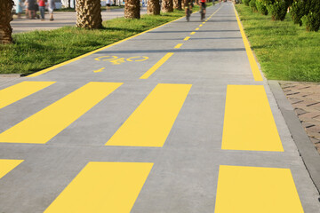Bicycle lane with painted yellow sign and pedestrian crossing outdoors