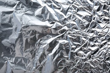 Crumpled silver foil as background, closeup view