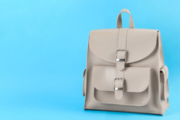 Stylish urban backpack on light blue background, space for text