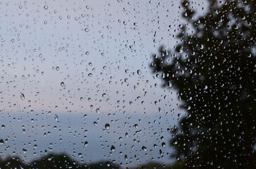 Window glass with water drops, closeup. Rainy weather