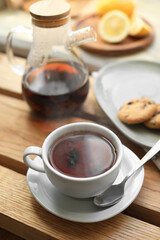Cup with delicious tea on wooden table