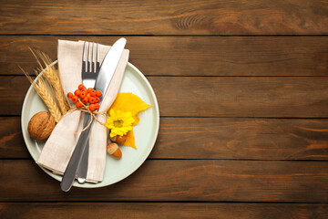 Top view of seasonal table setting with autumn items on wooden background, space for text....
