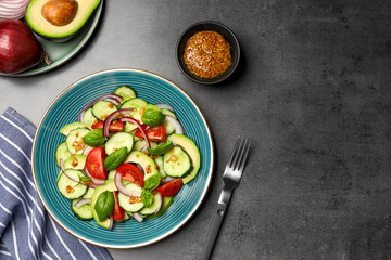 Tasty salad with cucumbers served on grey table, flat lay. Space for text