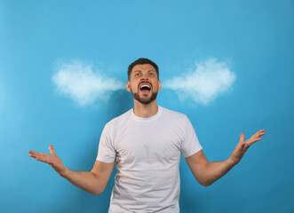 Aggressive man with steam coming out of his ears on light blue background