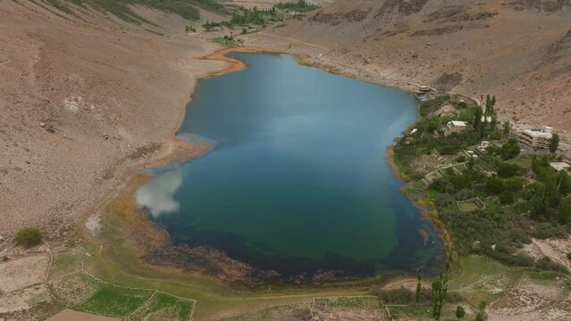 AERIAL 4 K, drone flights forward into a lake in the Himalayas, beatifull sky with clouds reflections in the surface of the water, filmes in Borith Lake, Hunza, Pakistan