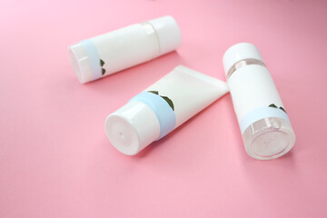 Flat lay cosmetic composition on pink background. Set of beauty products for lotion, cream, tonic, essence, cleanser, mask. Side view. Mock up.