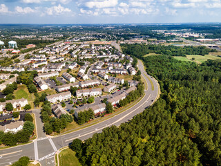  Aerial view of small winding streets, parking lots and roads in a residential area of a small town.
