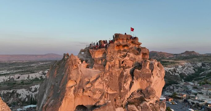 Aerial view of natural rock formations in the sunset, valley with cave houses in Cappadocia, Turkey. Natural landscape city lights at the night.