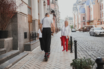 A frightened middle-aged woman passes a man on an electric scooter on the sidewalk in the city