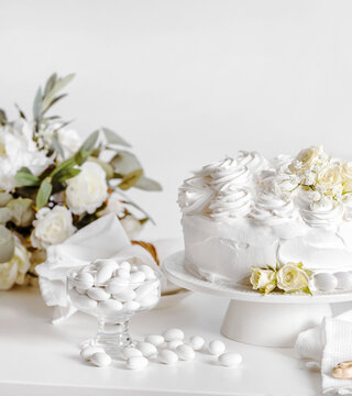 Wedding cake with roses againsta white background, with copy space