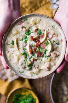 Clam chowder in a bowl held in hands