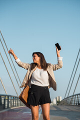 businesswoman dances in the street with her cell phone.