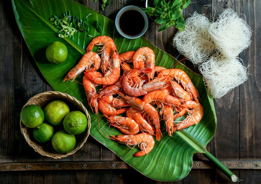ingredients for Thai cuisine - shrimp, rice noodles, mint, green onion, palm leaf composition, top view