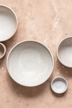 Five empty ceramic bowls on a pink background