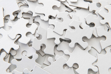 Pile of puzzle pieces - blank, studio shot on white