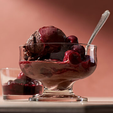 A bowl of chocolate gelato with wine poached cherries.