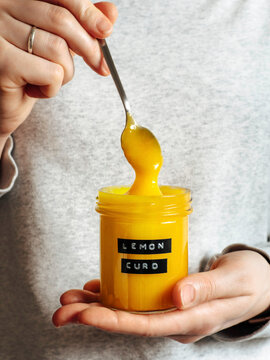Homemade lemon curd in hands, vertical