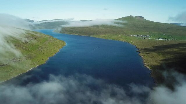 Aerial view of Sorvagsvatn lake or Leitisvatn, Biggest lake in Faroe Islands. Flying through the clouds. Amazing mist and foggy Faroese nature. High quality 4k footage.