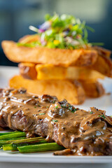 New York Strip Steak with Mushroom Cognac Peppercorn Gravy and Thick Cut Fries