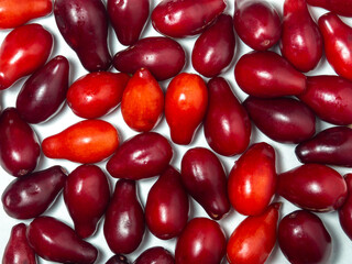 Dogwood berries on a white background. Lots of red berries. Useful fruit. Healthy food. Tart berry.