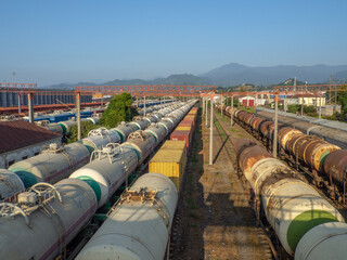  Railroad in the city against the backdrop of mountains.. Many railway paths. Wagons and trains on the tracks. unloading station. Tank wagons.
