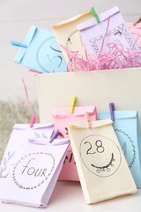 Colorful paper bags on white table, closeup. New Year advent calendar