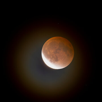 waning lunar eclipse with halo