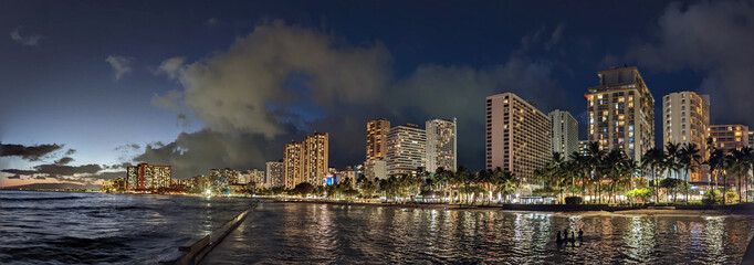 Panoramic of Ocean waters of Waikiki Beach at Night with Hotels aloing the coast