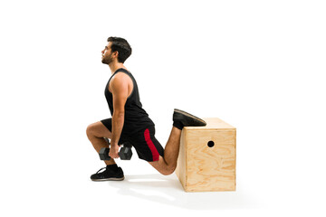 Attractive latin man using a plyo box to do leg lunges