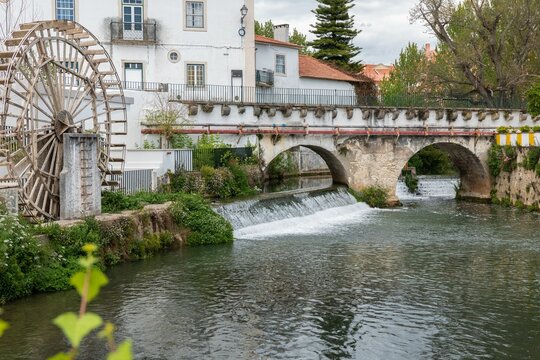 Old water wheel and the bridge by River Almonda in the old city of Torres Novas, Santarem, Portugal