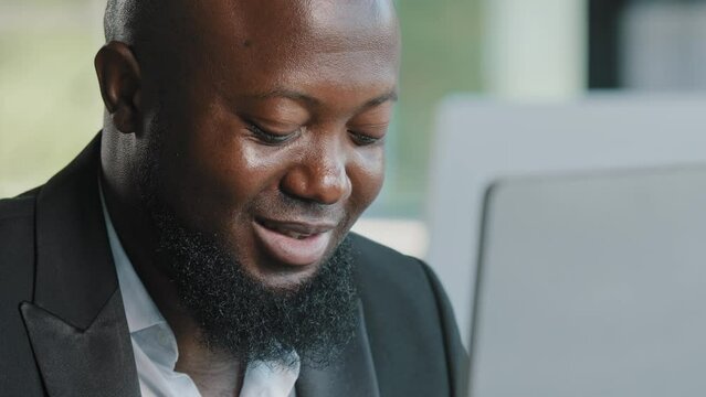 Close up male worker african american man bearded businessman guy employee specialist work on laptop in office space chatting with colleagues typing email programming code e-commerce trading business
