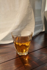 Hot tea cup on wooden table near white curtain window with nature sunlight in the morning.