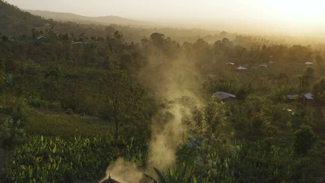 Aerial shot in the forest at sunset with smoke rising in Ethiopia