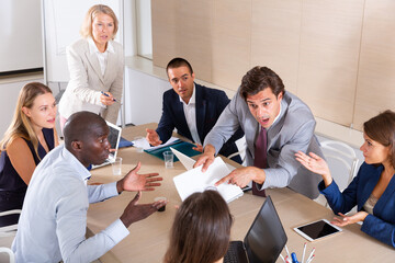 Group portrait of business team brainstorming emotionally in office