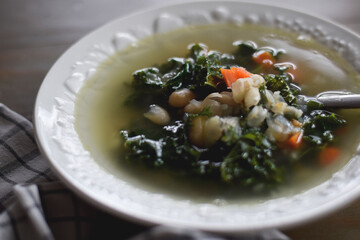 Bowl of white bean and kale soup on table