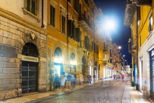 Vibrant nightlife of Verona illuminated central streets on warm fall, Italy.