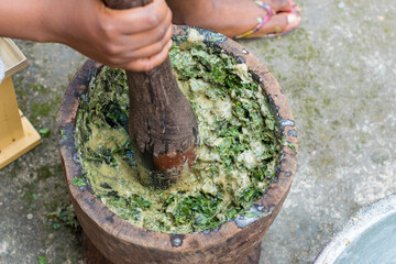 African Nigerian female, lady or woman's hand doing house chores and using a wooden pestle and...