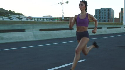 Running, fitness and runner workout of a woman training in a city street. Sport motivation and focus of a healthy, strong and sports athlete exercise for health, cardio and wellness on a urban road