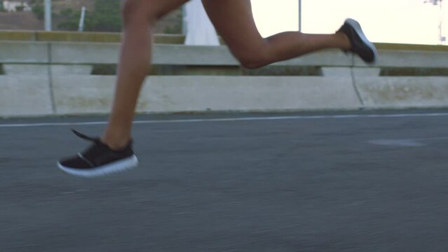 Running, exercise and fitness with legs of a woman runner training for a sports race on her workout in the city. Motivation, health and cardio to follow a strong and fast female athlete taking a run