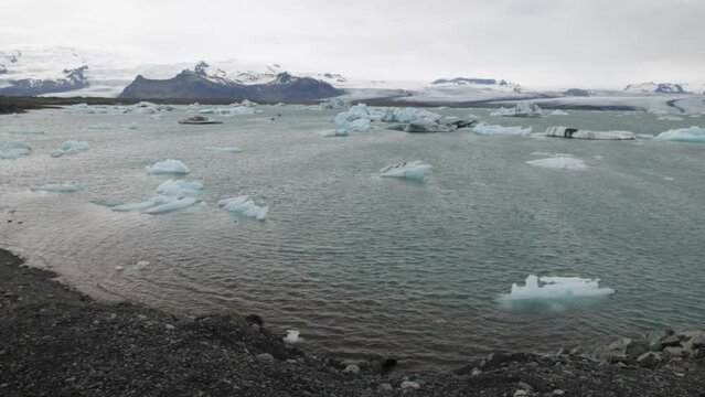 Glacier Lagoon in Iceland with side view of male photographer and left to right pan.